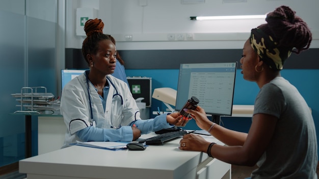 Doctor holding bottle of pills for treatment against disease