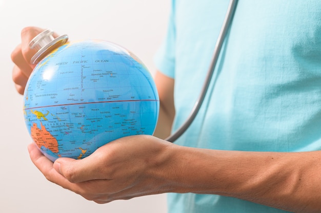 doctor holding an earth globe for consulting with stethoscope