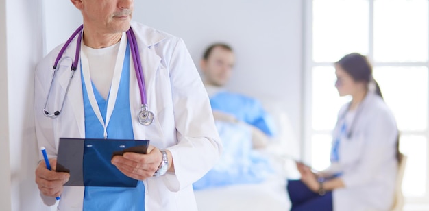 Doctor holding folder in front of a patient and a doctor