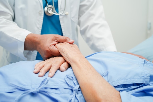 Doctor holding hands Asian elderly woman patient help and care in hospital