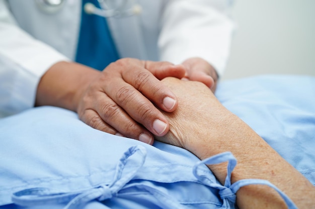 Doctor holding hands Asian elderly woman patient help and care in hospital