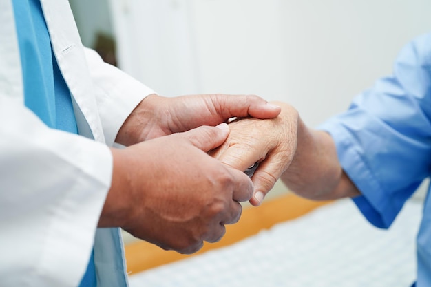 Doctor holding hands Asian elderly woman patient help and care in hospital