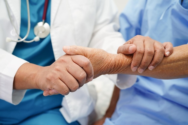 Doctor holding hands Asian elderly woman patient help and care in hospital