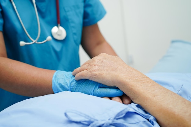 Doctor holding hands Asian elderly woman patient help and care in hospital