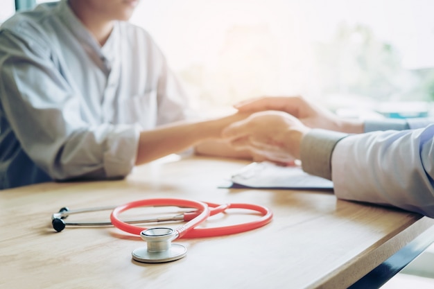 Doctor holding hands for comforting and care patient