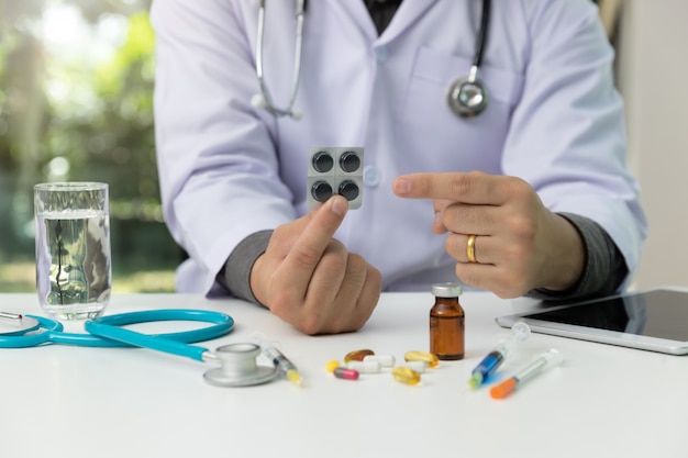 Doctor holding medicine pills in hand and explained medication 