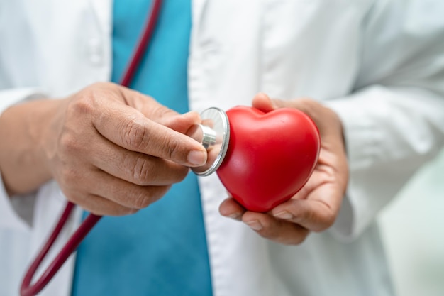 Doctor holding a red heart in hospital ward healthy strong medical concept