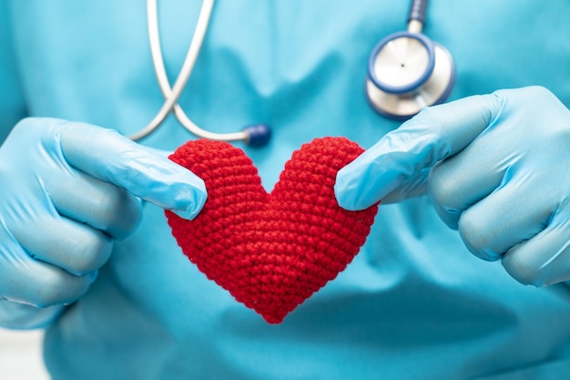 Doctor holding a red heart in hospital ward healthy strong medical concept