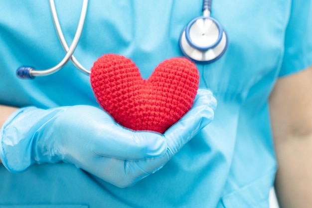 Doctor holding a red heart in hospital ward healthy strong medical concept