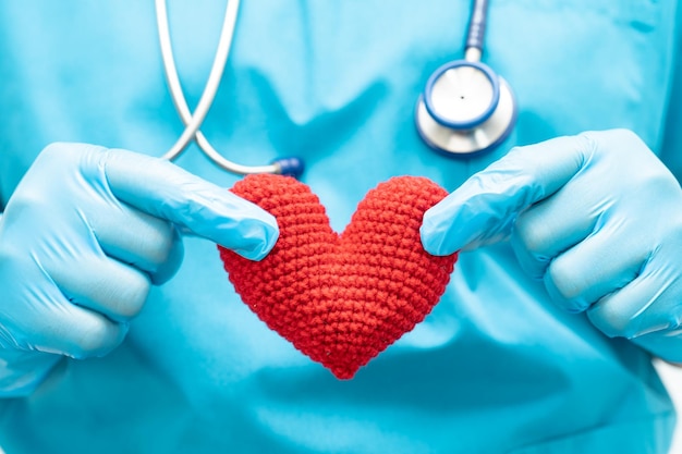 Doctor holding a red heart in hospital ward healthy strong medical concept