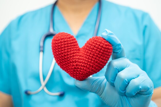 Doctor holding a red heart in hospital ward healthy strong medical concept