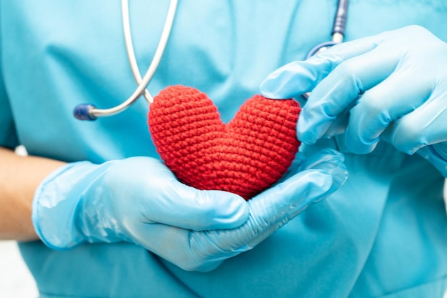 Doctor holding a red heart in hospital ward healthy strong medical concept