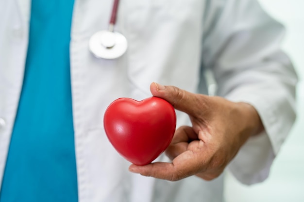 Doctor holding a red heart in hospital ward healthy strong medical concept