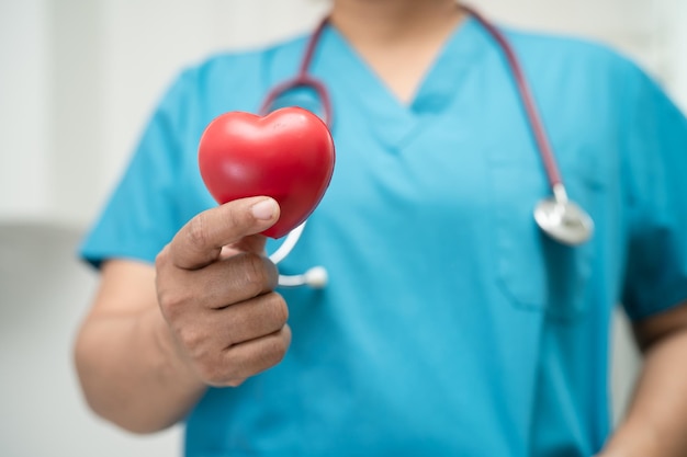 Doctor holding a red heart in hospital ward healthy strong medical concept