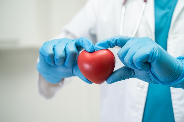 Doctor holding a red heart in hospital ward healthy strong medical concept