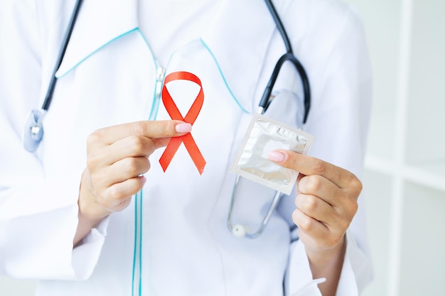 Doctor holding a red ribbon as a symbol of AIDS.