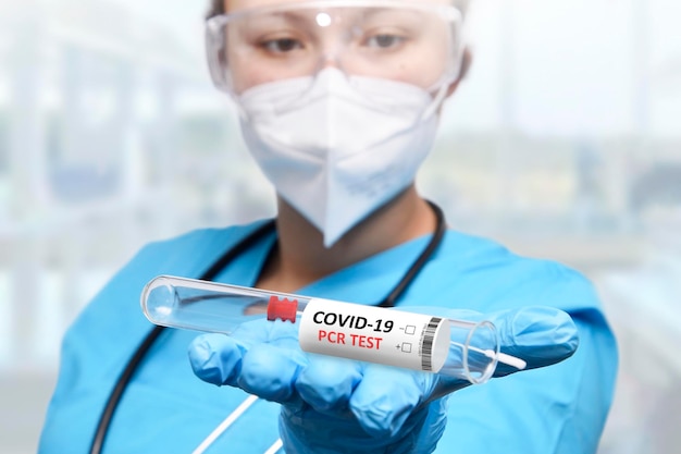 A doctor holding a test tube with the word coronavirus on it