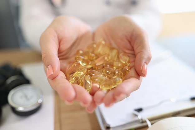 Doctor holding transparent yellow capsules in hands