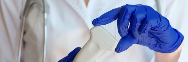 Doctor holding ultrasound scanner in clinic closeup medical checkup of internal organs concept