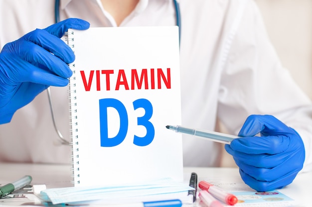 Doctor holding a white card in hands and pointing the word VITAMIN D3. Healthcare conceptual for hospital, clinic and medical busines.