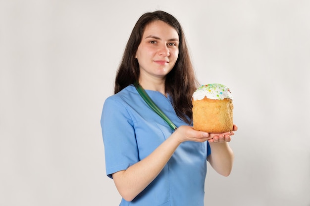 The doctor holds an Easter cake and smiles