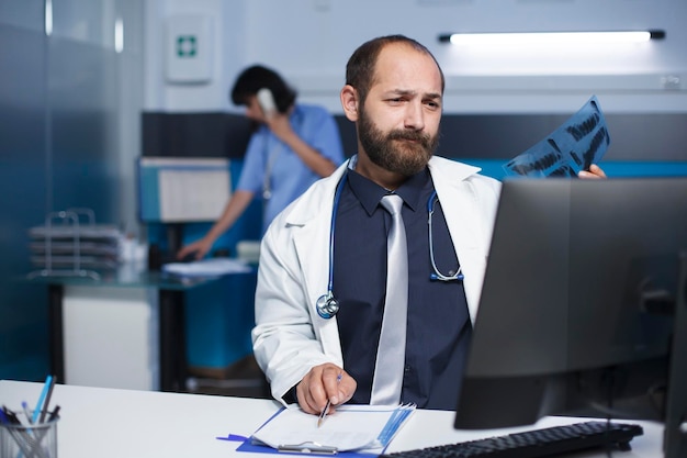 Doctor holds and examines an xray scan