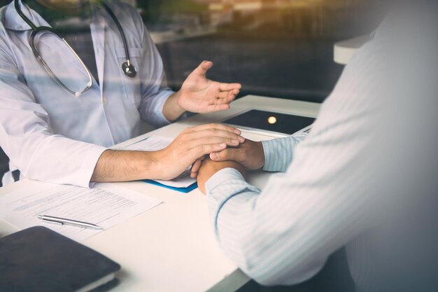 Doctor holds hands and leaves comforting counselors to patient