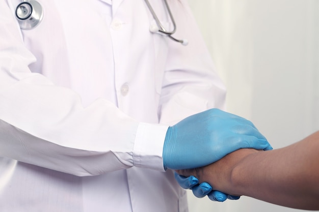 The doctor holds the patient's hand to encourage healing.