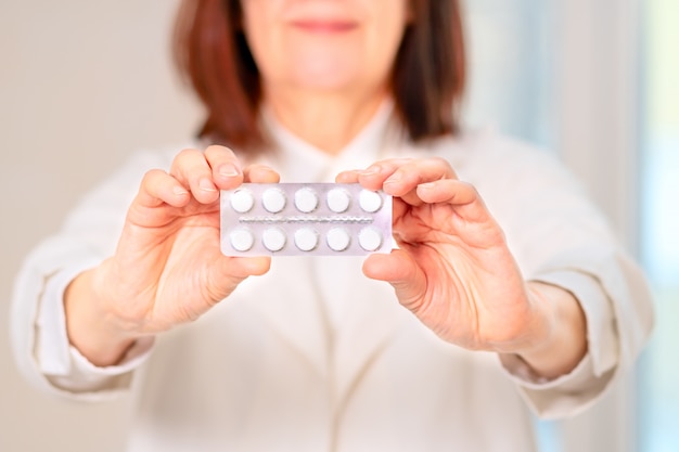 Doctor holds pills in his hands.