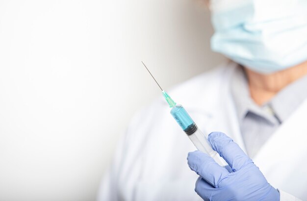 The doctor holds the syringe for the vaccine