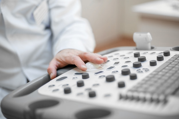 The doctor holds an ultrasound on the patient, a hand close up