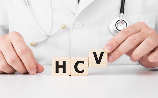 Doctor holds wooden cubes in his hands with text HCV