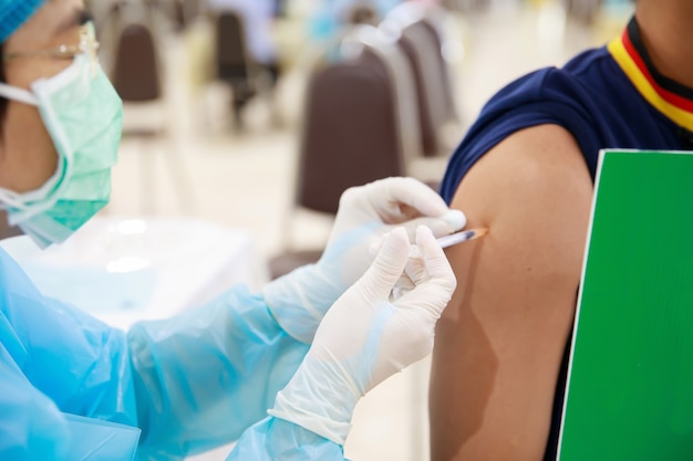 doctor injecting flu vaccine covid19 or flu antivirus vaccine patients arm in local hospital