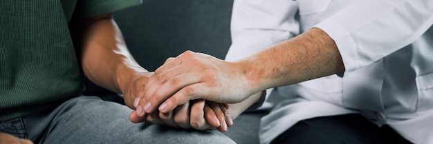 Doctor is holding the hand of the patient by giving him confidence in the doctor