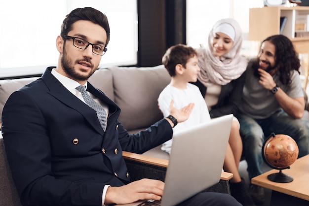 Doctor is Holding Laptop and Pointing on Family.