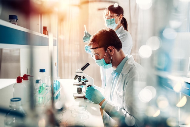 Doctor in the laboratory analyzes samples of codiv under a microscope