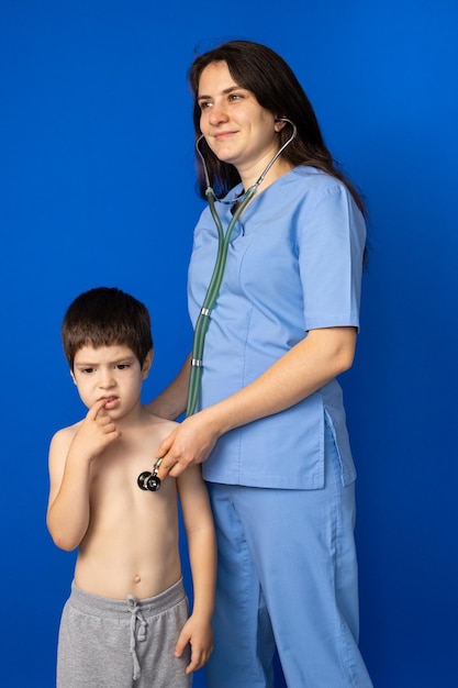 The doctor listens to the heart and lungs of a 5yearold boy with a stethoscope