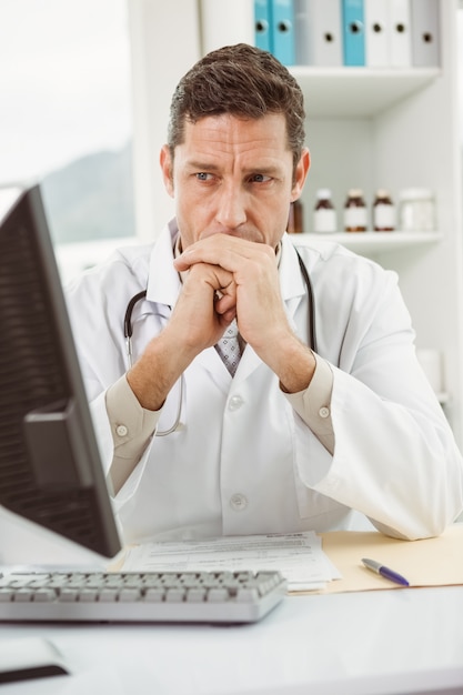 Doctor looking at computer in medical office