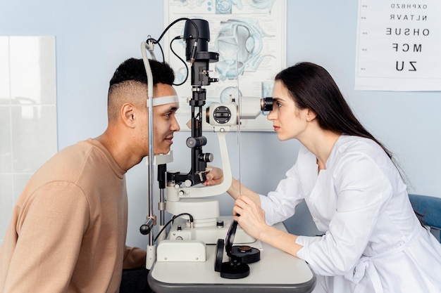 A doctor looks at an eye exam with a patient.