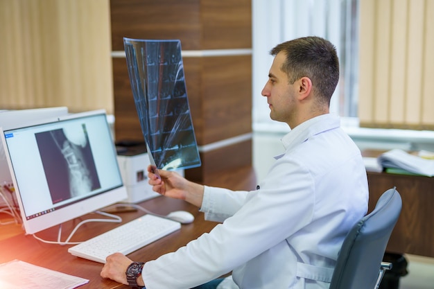 Doctor looks at an xray and checking the diagnosis.