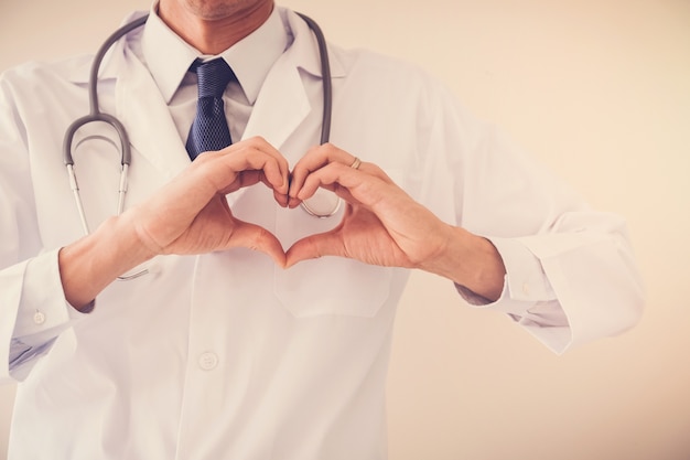 Doctor making his hands in heart shape, heart health,  health insurance concept