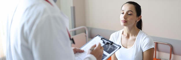 Doctor in mask communicates with patient in clinic  ultrasound and medical diagnosis concept