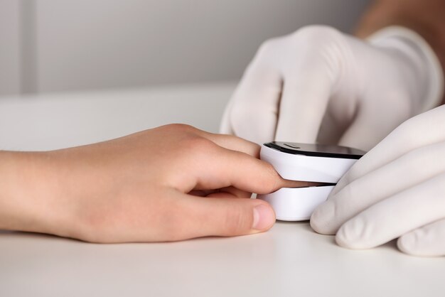 A doctor measures blood oxygen and heart rate with a pulse oximeter.