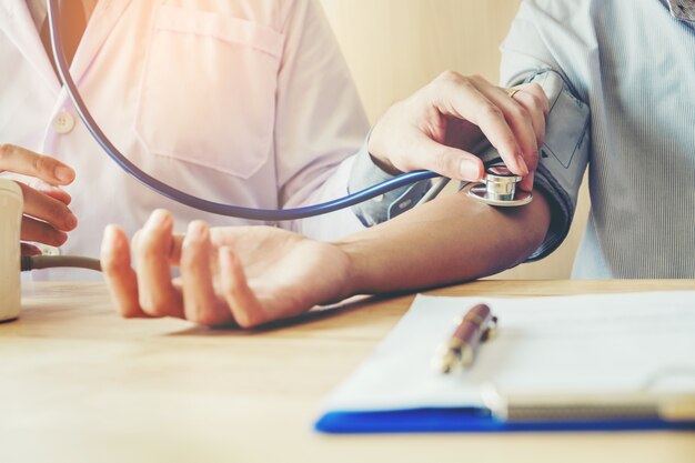 Doctor Measuring arterial blood pressure woman patient