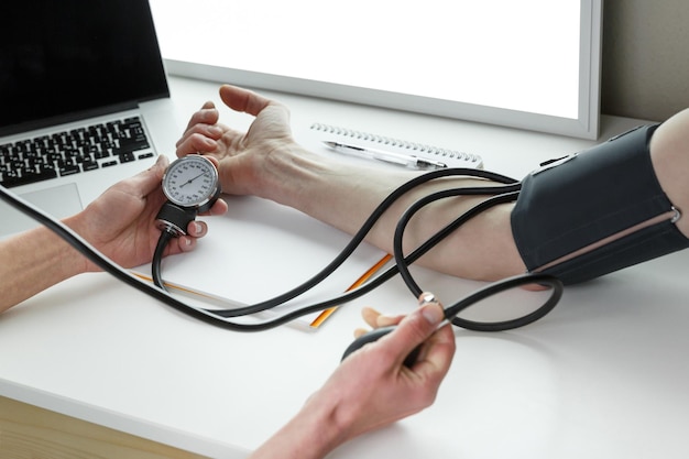 Doctor measuring blood pressure in a clinic Healthcare industry concept