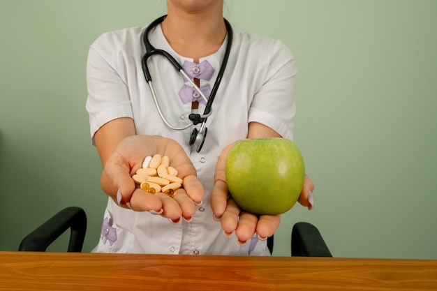 Doctor in medical gown offering alternatives fresh apple or pills