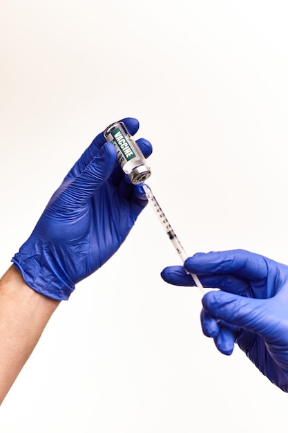 Doctor, nurse, scientist, researcher hand in blue gloves holding coronavirus, covid-19 vaccine disease preparing for vaccination, medicine and drug concept.