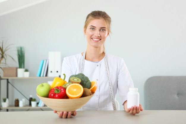 Doctor nutritionist in her office demonstrates the concept of healthy eating