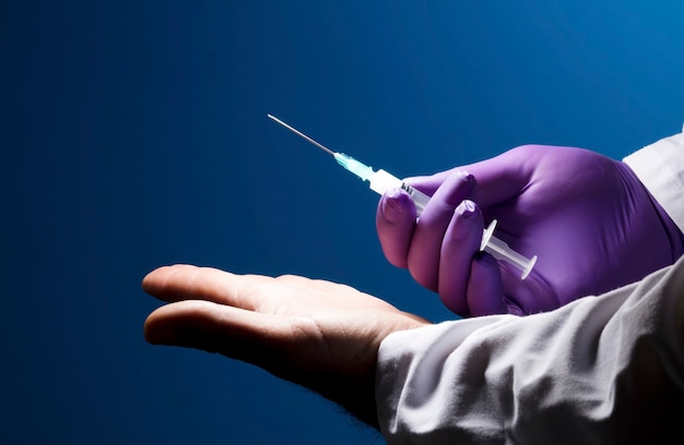 doctor offers vaccine with kind gesture, syringe and purple glove