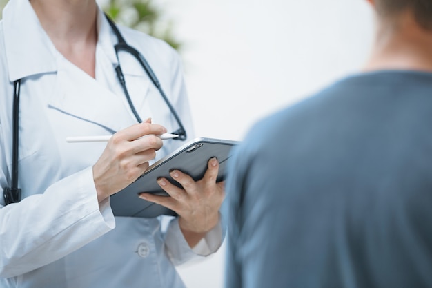 The doctor in the office conducts a consultation with the patient in a bright office